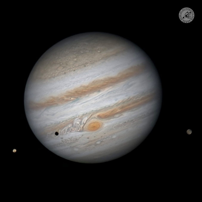 In questa foto la regione della Grande Macchia Rossa (GMR), in procinto di transitare quasi in prossimità del centro del disco planetario, mentre Ganimede si allontana sulla destra, al sopraggiungere, dalla sinistra, di Io che proietta la sua ombra netta su Giove. - Copyright: Gabriele D'Orazio 