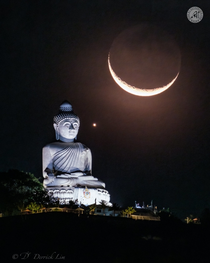 Questa meravigliosa scena si è verificata dopo l'occultazione lunare di Venere del 23 marzo 2023. Mentre Venere e la Luna si separano e tramontano sull'isola di Phuket (Thailandia), sembrano visitare la famosa gigantesca statua del Big Buddha. - Copyright: Derrick Lim 